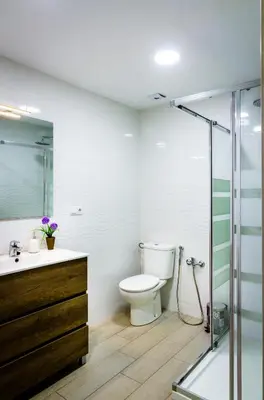 a bathroom with a toilet and a glass shower at Casa En La Playa Del Rey in Mareny Barraquetas