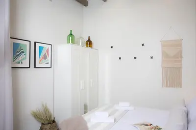a living room with a white cabinet with bottles on it at Buenos Aires Apartments in Valencia