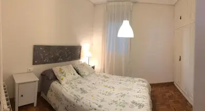 a bedroom with a bed and a lamp and a window at KM0 CENTRO CIUDAD in Valencia