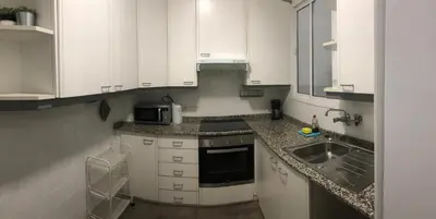 a small kitchen with white cabinets and a sink at KM0 CENTRO CIUDAD in Valencia