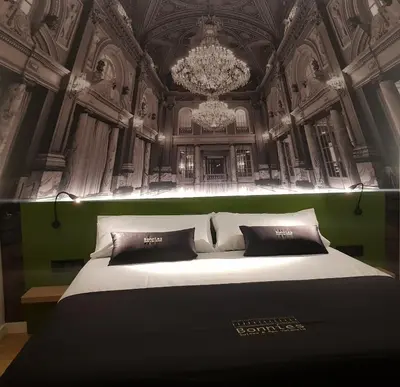 a bedroom with a large bed with a chandelier at BONNIES Suites & Spa Valencia in Valencia