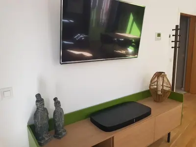 a tv on a wall with vases on a table at BONNIES Suites & Spa Valencia in Valencia
