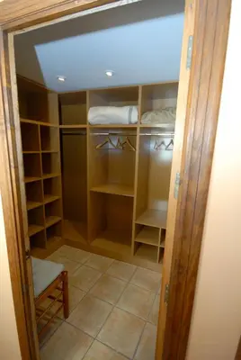 a walk in closet with wooden doors and shelves at Casa La Posada de Chella in Chella