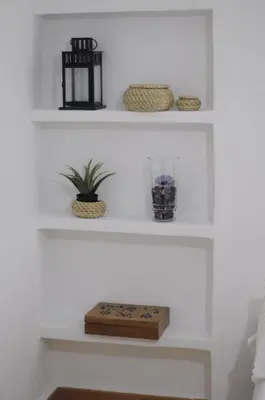 a white shelf with some plants and bowls on it at Casa La Posada de Chella in Chella