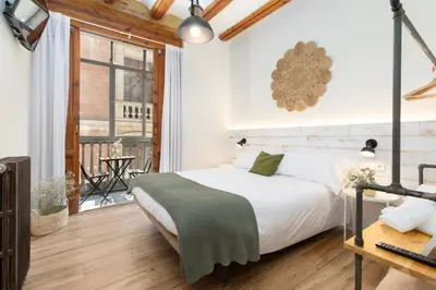a bedroom with a white bed and a window at Casa del Patriarca in Valencia