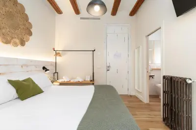 a bedroom with a large white bed and a bathroom at Casa del Patriarca in Valencia