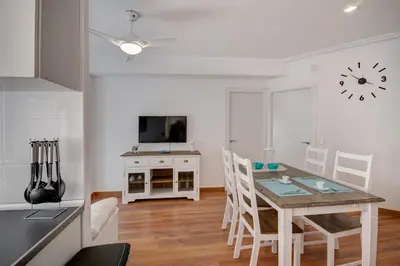 a kitchen and living room with a table and a clock at Beds & Breaks Glinka in Valencia