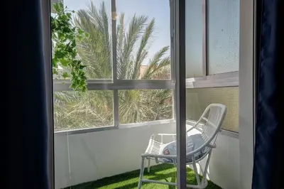a white bedroom with a large white bed with blue pillows at Beds & Breaks Glinka in Valencia