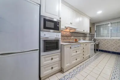 a kitchen with white cabinets and a white refrigerator at My Loft 4 You Gran Via in Valencia