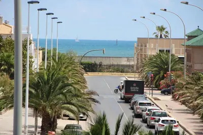a street with cars parked on the side of a road with the ocean at CasaMalva in Valencia