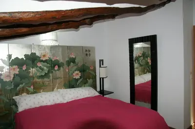 a bedroom with a pink bed and a large mirror at Casa rural El Majuelo in Portera