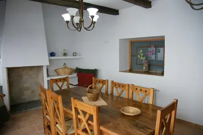 a dining room with a wooden table and chairs at Casa rural El Majuelo in Portera