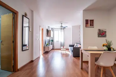 a dining room and living room with a table and chairs at Flats Burjasot in Valencia