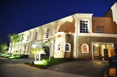 a large white building with palm trees in front of it at Hotel Luve in San Antonio de Banageber