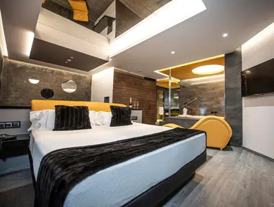 a bedroom with a large bed and a kitchen at Hotel Luve in San Antonio de Banageber
