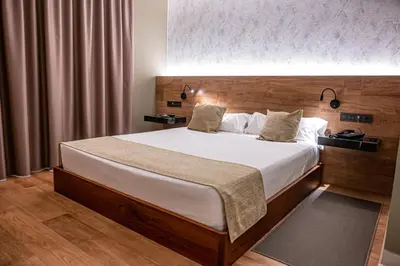 a bedroom with a large bed with white sheets at Hotel Luve in San Antonio de Banageber