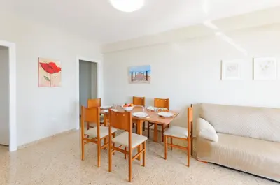 a dining room with a table and chairs and a couch at Turia in Tavernes de Valldigna