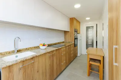 a kitchen with wooden cabinets and a sink at Turia in Tavernes de Valldigna