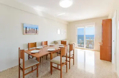 a dining room with a table and chairs and the ocean at Turia in Tavernes de Valldigna