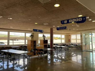 a dining room with tables and chairs in a building at Area de servicio El Rebollar in Requena