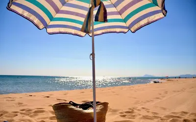 a beach umbrella on the sand on a beach at La Isla del Júcar in Barraca de Aguas Vivas