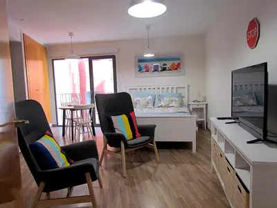 a room with a bedroom with a bed and chairs at Your Home at Valencia, El Carme in Valencia