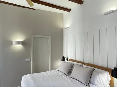 a bedroom with a large bed with white sheets at Cosy Rooms Embajador in Valencia