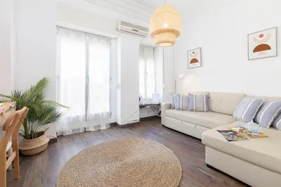 a white living room with a couch and a table at Travel Habitat Cabanyal in Valencia