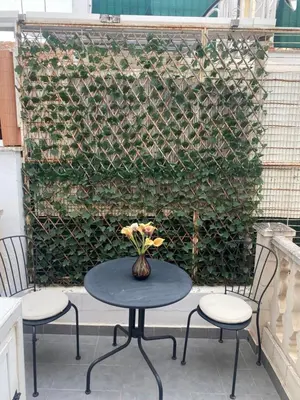 a table with two chairs and a vase with flowers at Travel Habitat Cabanyal in Valencia