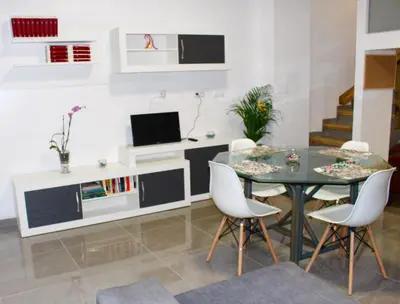 a dining room with a glass table and white chairs at Apartamento Luminoso cerca de la PLAYA y PUERTO in Valencia