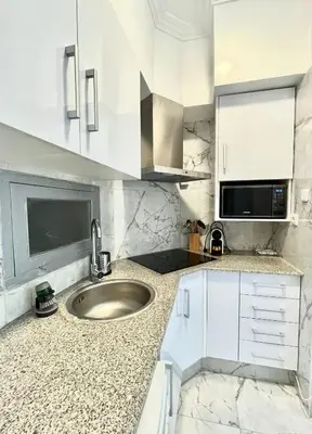a white kitchen with a sink and a microwave at Apartamento Luminoso cerca de la PLAYA y PUERTO in Valencia