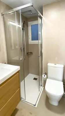 a bathroom with a toilet and a glass shower at Disfruta de unos días en la playa ¡Y mucho más! in Burriana