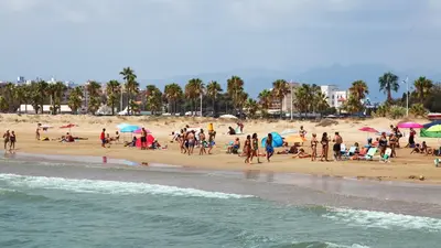 a group of people on a beach with umbrellas at Disfruta de unos días en la playa ¡Y mucho más! in Burriana