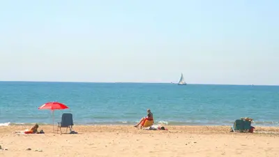 a group of people on a beach with a sail boat at Disfruta de unos días en la playa ¡Y mucho más! in Burriana