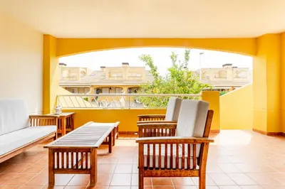 a balcony with chairs and a couch on a balcony at Family-Friendly Beach House ideal for Holidays & Workers at Beach Sagunto Valencia in Sagunto