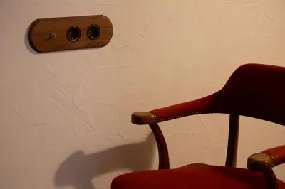 a red chair sitting in front of a wall with a thermost at Natural loft in Valencia
