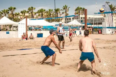 three men playing a game of volley ball on the beach at Casa Quintero Valencia Playa Cabañal in Valencia