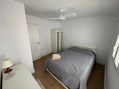 a bedroom with a bed and a ceiling fan at Casa Quintero Valencia Playa Cabañal in Valencia