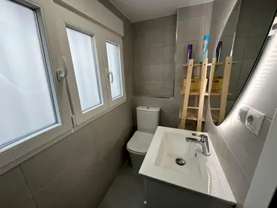 a bathroom with a sink and a toilet and a mirror at Casa Quintero Valencia Playa Cabañal in Valencia