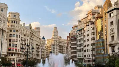 a city with a fountain in front of buildings at Cosy Rooms Bolsería in Valencia