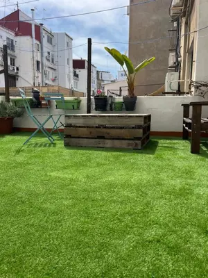 a yard with green grass and plants on a building at Apartamento Ruzafa Centro II in Valencia