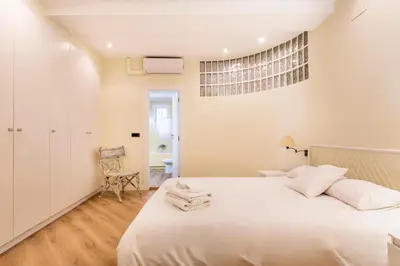 a bedroom with a large white bed and a chair at Apartamento Ruzafa Centro II in Valencia