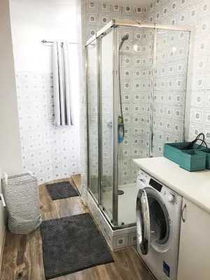 a bathroom with a shower and a washing machine at Harbor Apartments Valencia in Valencia