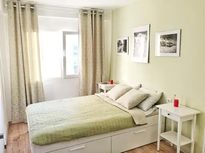 a white bedroom with a bed and a window at Harbor Apartments Valencia in Valencia