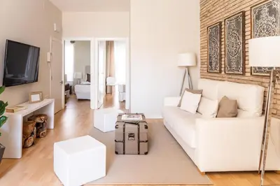 a living room with a white couch and a tv at MD Puerto Rico in Valencia