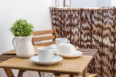 a wooden table with two white cups and saucers on it at MD Puerto Rico in Valencia