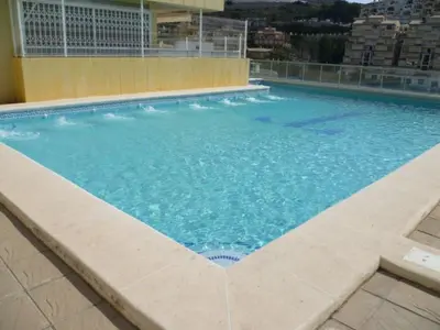 a large swimming pool with blue water in a building at Hetesa 2000, 3º-7 in Cullera