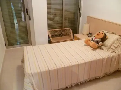 a teddy bear sitting on a bed in a bedroom at Hetesa 2000, 3º-7 in Cullera
