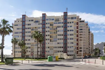 a large building with palm trees in front of it at EL RACO- C, 8-16 in Cullera