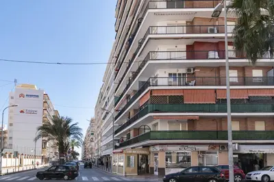 a tall building with cars parked on a street at Europa A- 12º-23 in Cullera